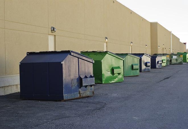 a forklift lifts a full dumpster from a work area in Cartersville